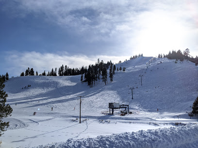 Winter sports scene at Warner Canyon Ski Resort in Lakeview, Oregon, featuring a ski lift ascending amidst snow-covered slopes under the clear sky, presenting a stunning winter scenery.