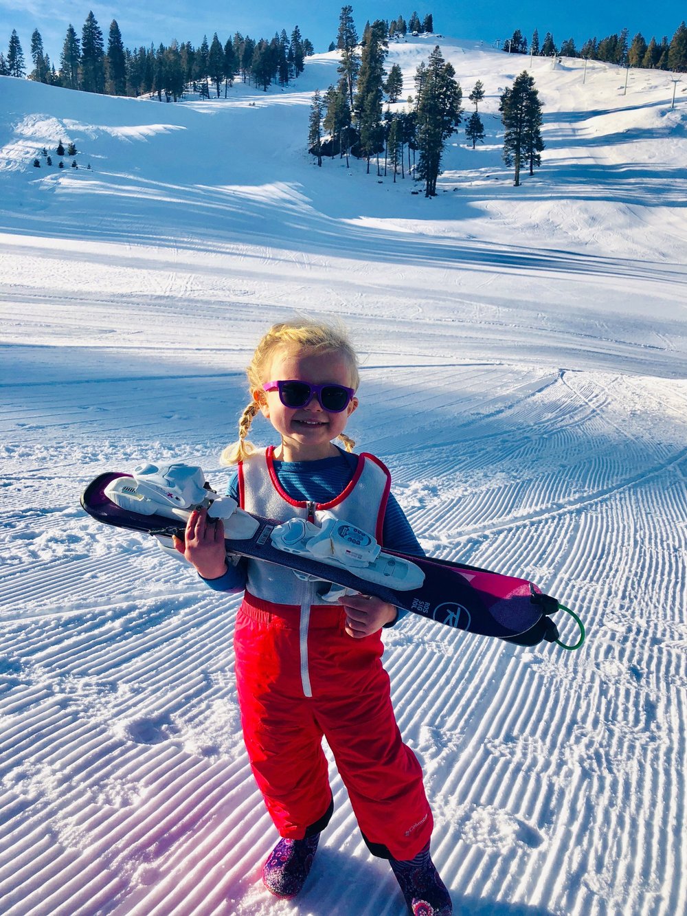 Warner Canyon in USA - a little girl holding a snowboard in the snow.
