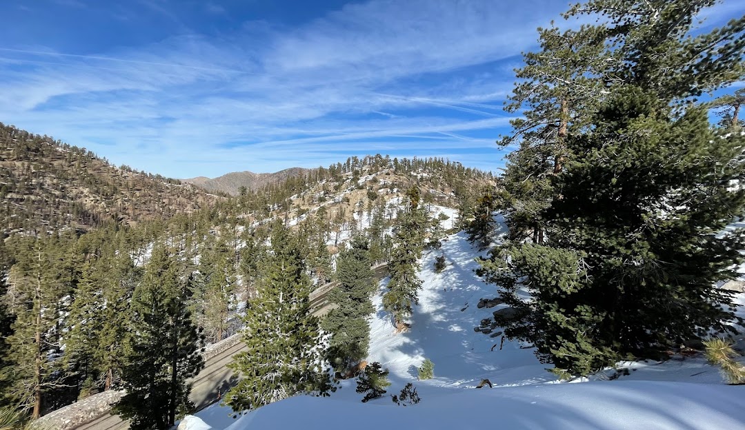 A winter sports scene on Mt Waterman in Pearblossom California with snow-covered slopes visible at the ski resort. The mountain landscape provides a scenic backdrop for the wintery fun.
