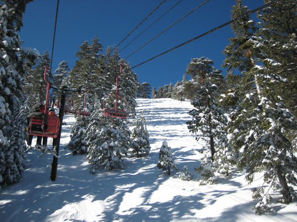 A skier enjoys the snow-covered slopes at Mt Waterman in Pearblossom California providing a winter sports scene. The ski lift of the resort stands prominent in the chilly landscape.