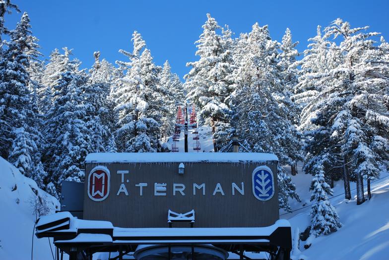 A ski resort at Mt Waterman in Pearblossom, California, bustling with winter sports activity. The scene is characterized by captivating winter scenery with a prominent ski lift.