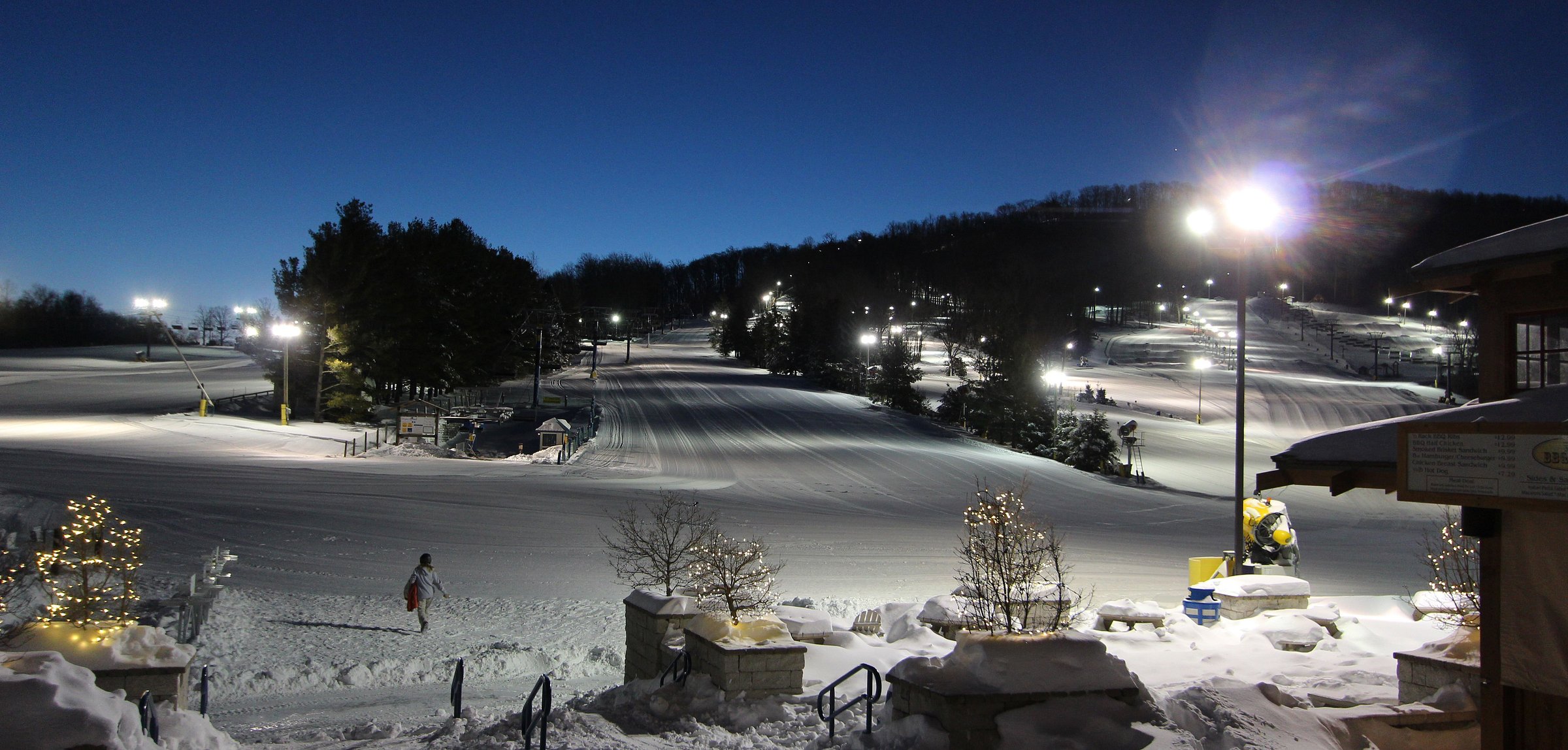 Winter sports scene at Liberty Mountain, Fairfield, Pennsylvania, featuring a ski resort amidst stunning winter scenery, a winter sports center, and a chalet in the distance.