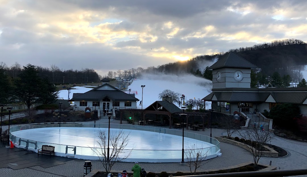 A ski resort at Liberty Mountain in Fairfield Pennsylvania is buzzing with winter sports activity. The scene showcases a stunning winter landscape with snow covered slopes.