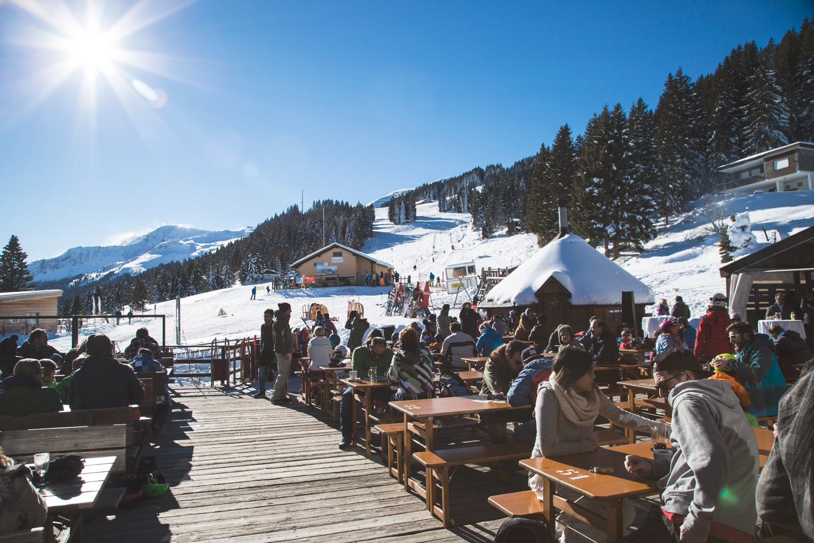Wolzenalp in Switzerland - a group of people sitting at tables in the snow.