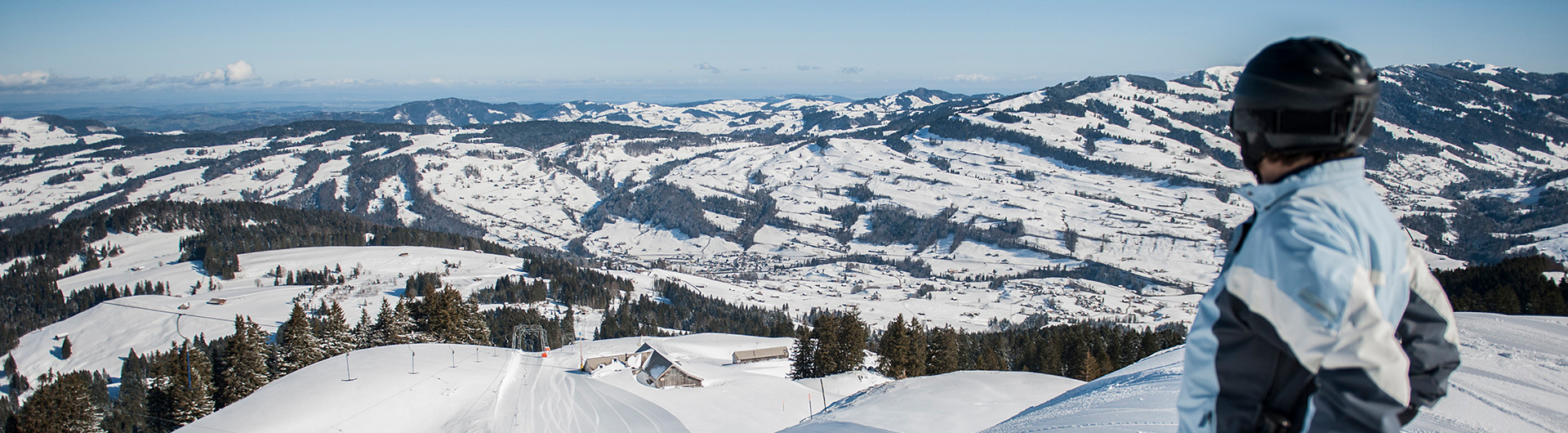 Winter sports enthusiasts enjoying a day at Wolzenalp ski resort in Eastern Switzerland, surrounded by stunning snowy scenery and charming Swiss chalets.