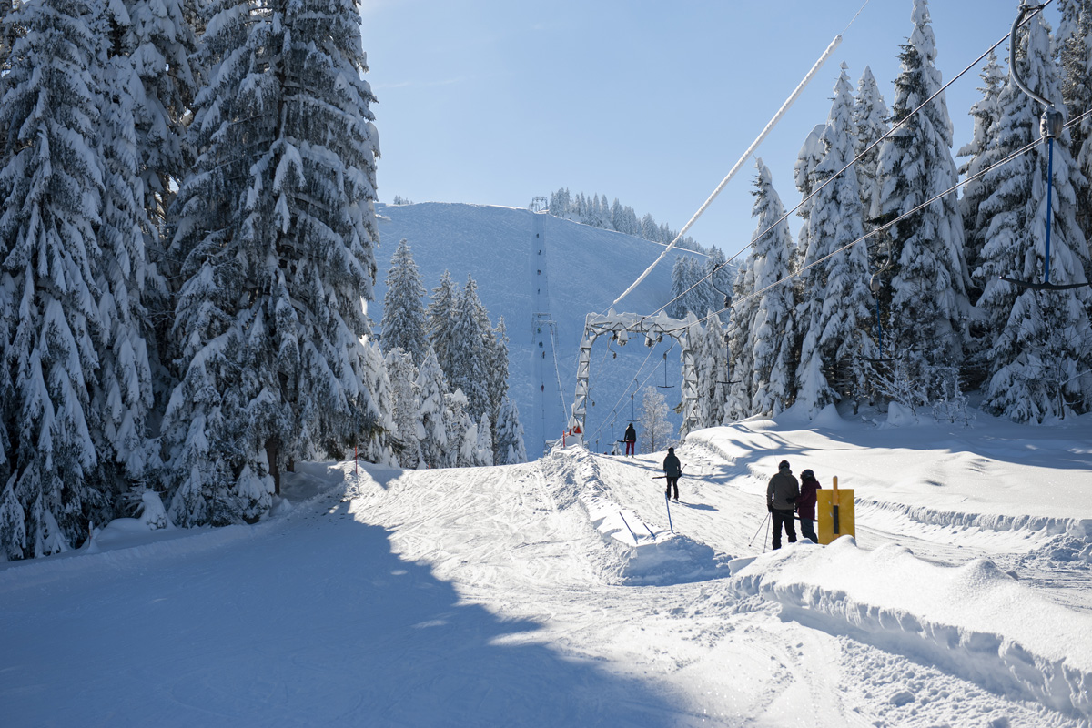 A winter sports scene at Wolzenalp in Switzerland showcasing a ski lift and resort amidst stunning winter scenery. Perfect for skiing and other winter activities.
