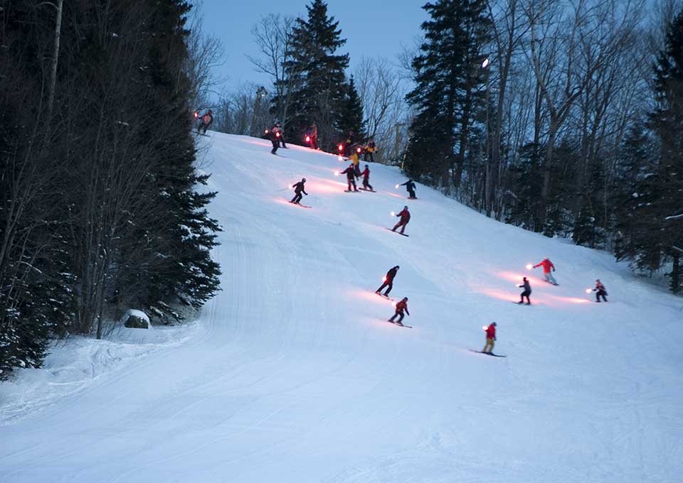 Winter sports scene at Searchmont Ski Resort in Ontario, Canada, featuring a group of skiers, including a family, enjoying the snow-covered slopes.