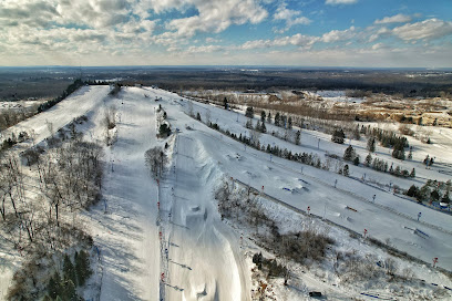 Winter sports enthusiasts enjoying a day at Mt Holly ski resort in Holly, Michigan, USA. The stunning white landscape provides an idyllic backdrop for the exciting activities.