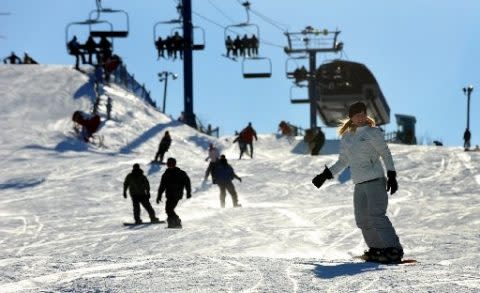 Mt Holly in USA - a group of people skiing down a snowy slope.