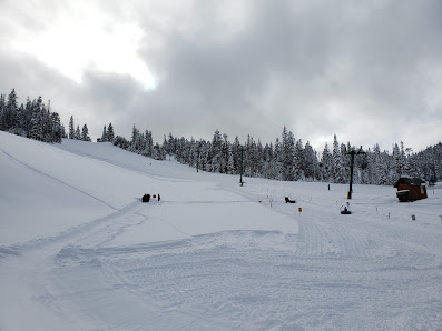 A scenic view from Cooper Spur ski resort in Hood River Oregon USA boasting a winter sports scene with a ski lift skiers and snow-covered slopes.