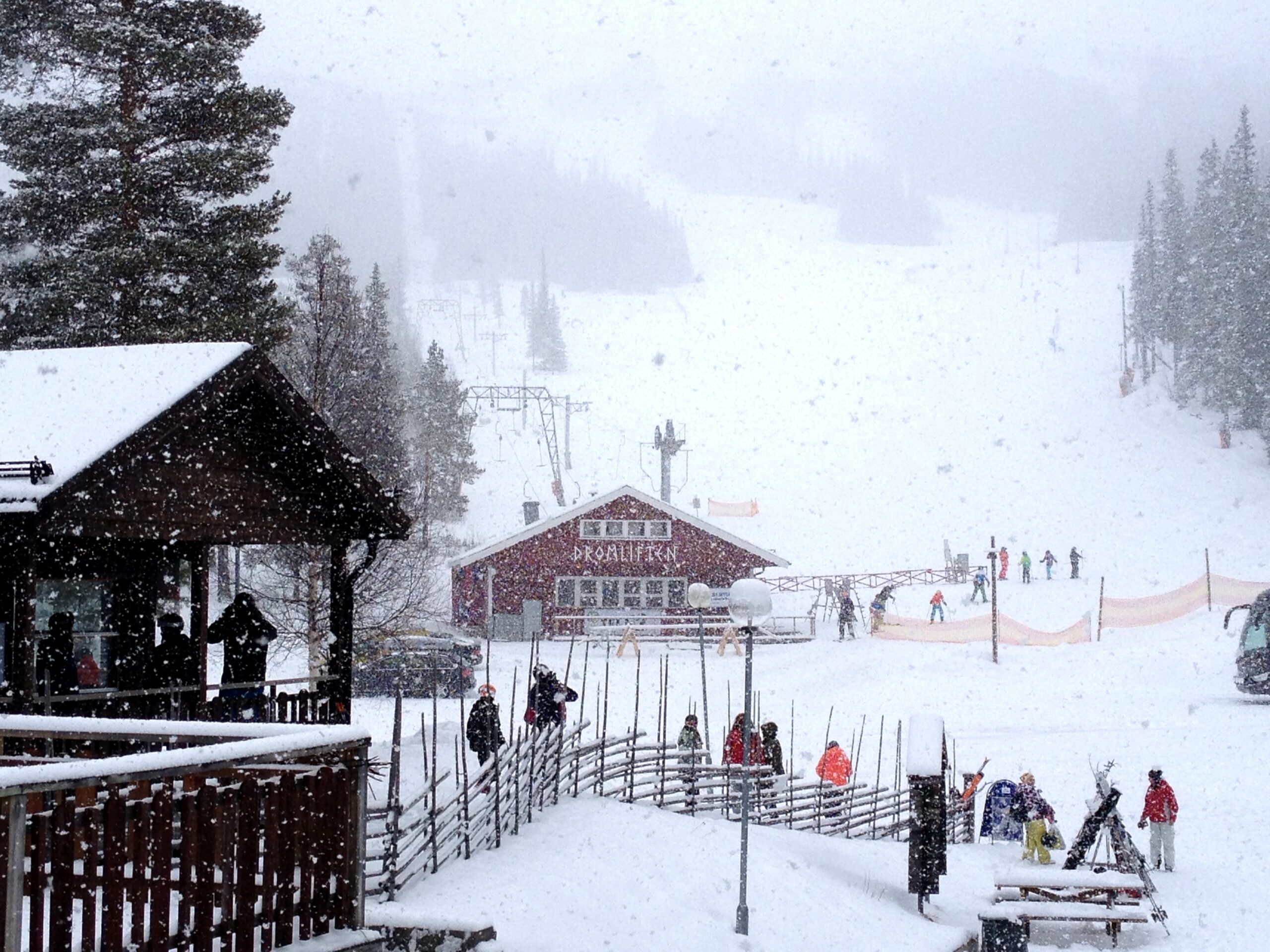 Winter sports enthusiasts in action at Bydalsfjällen ski resort in Northern Sweden, set against a spectacular snowy landscape, with a ski lift taking excited skiers up the slopes.