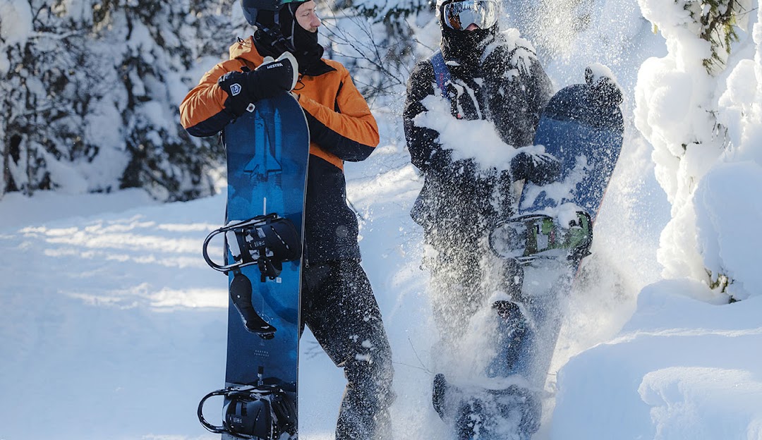 A snowboarder in action, skillfully navigating the snow-covered slopes of Bydalsfjällen – Bydalen in northern Sweden, surrounded by pristine white landscapes under clear skies.