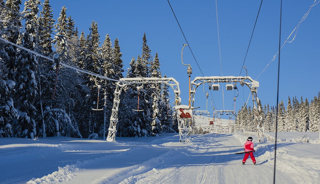 A scenic view of Bydalen ski resort in Northern Sweden showcasing a ski lift a skier and a bustling winter sports scene set in the stunning Bydalsfjällen.