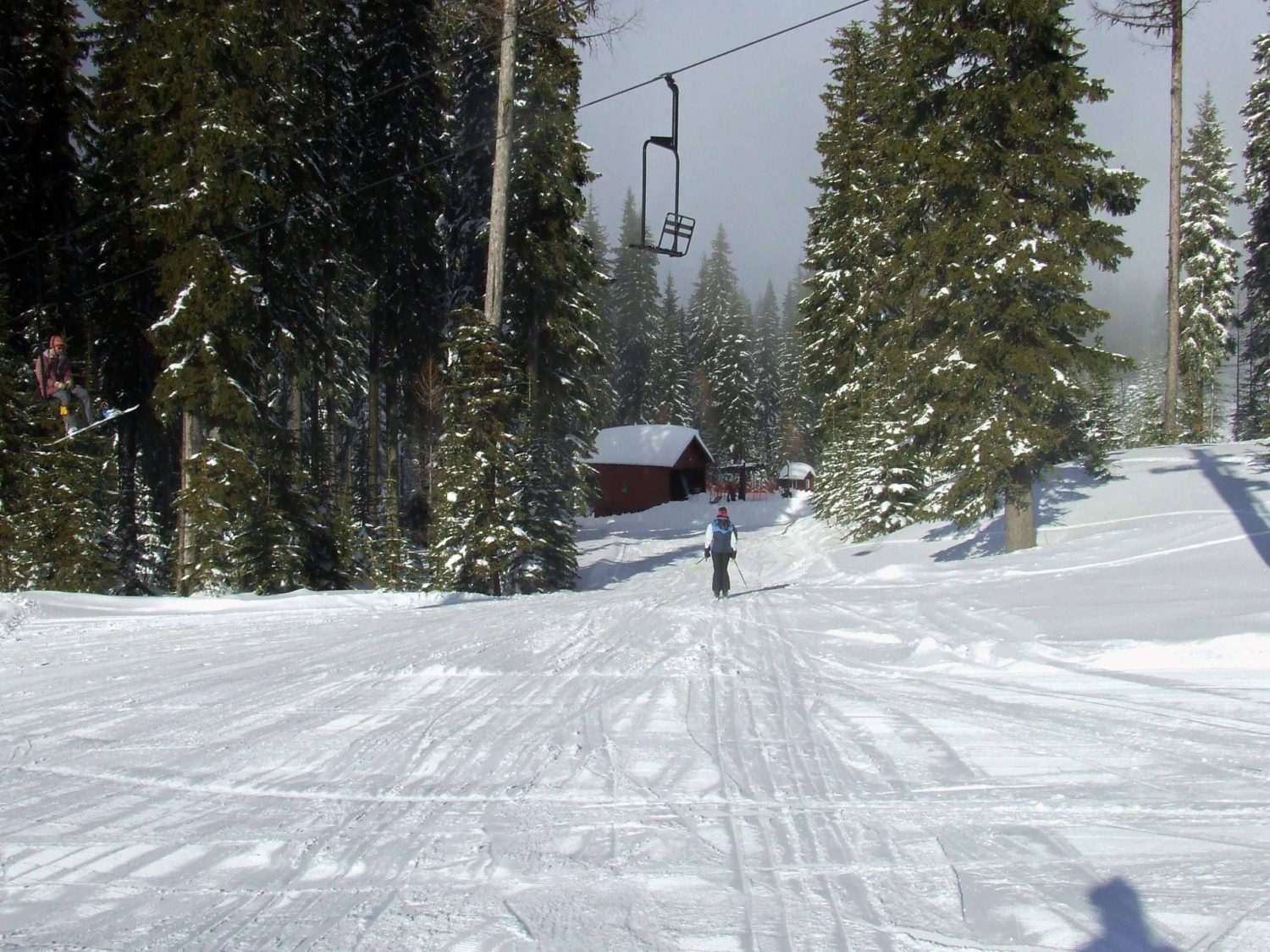 A skier is enjoying a run at Spout Springs ski resort in Weston Oregon USA. The scene includes a ski lift and the surrounding winter sports scene depicting a vibrant day at this winter sports centre.