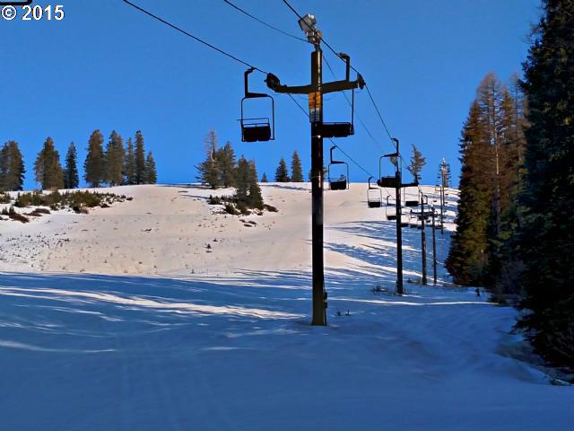 A ski lift ascends the snow-covered slopes at Spout Springs in Weston Oregon. Skiers can be seen enjoying the winter sports scene at this bustling ski resort.