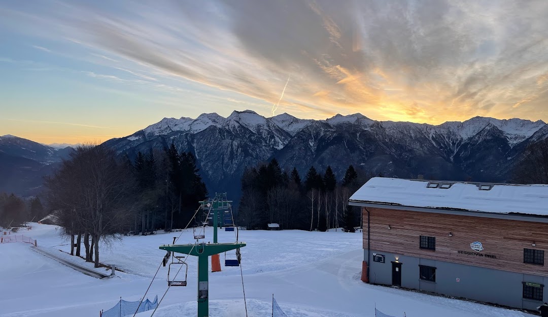 Winter scene at Domobianca ski resort in Piedmont, Italy featuring bustling ski slopes, ski lift and breathtaking winter scenery.