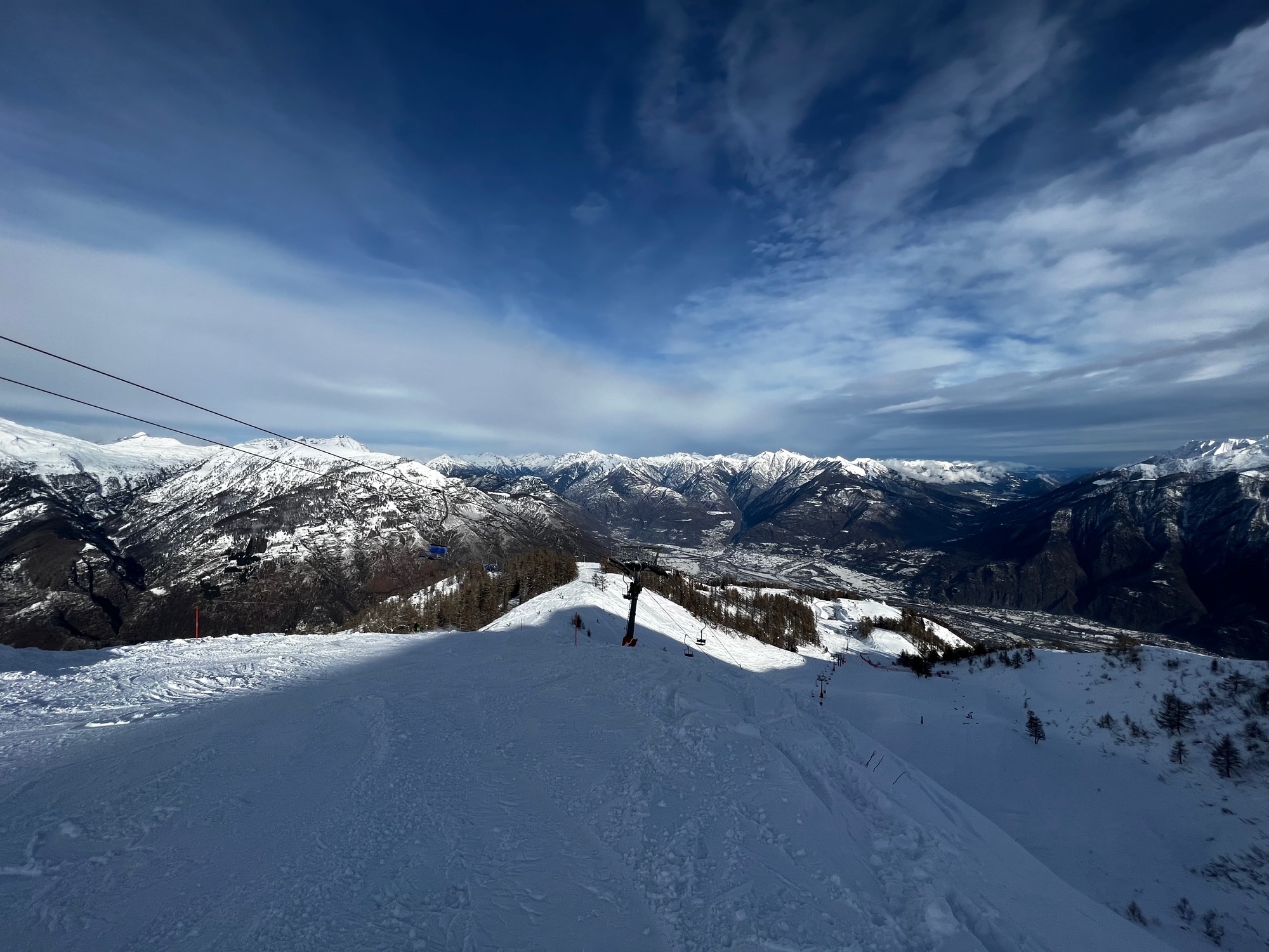 A snowy scene at Domobianca ski resort in Piedmont Italy featuring a charming chalet majestic mountain and numerous winter sports enthusiasts enjoying the pristine slopes.