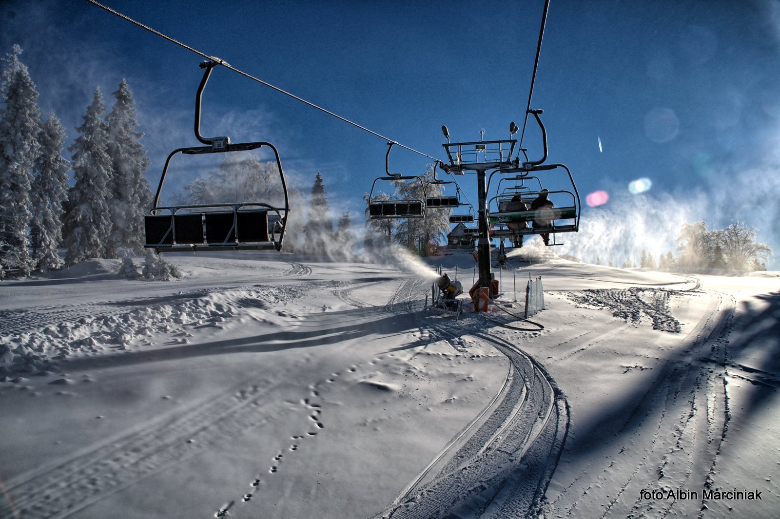 Dwie Doliny - wyciąg krzesełkowy Szczawnik I in Poland - a ski lift going up a snowy hill.