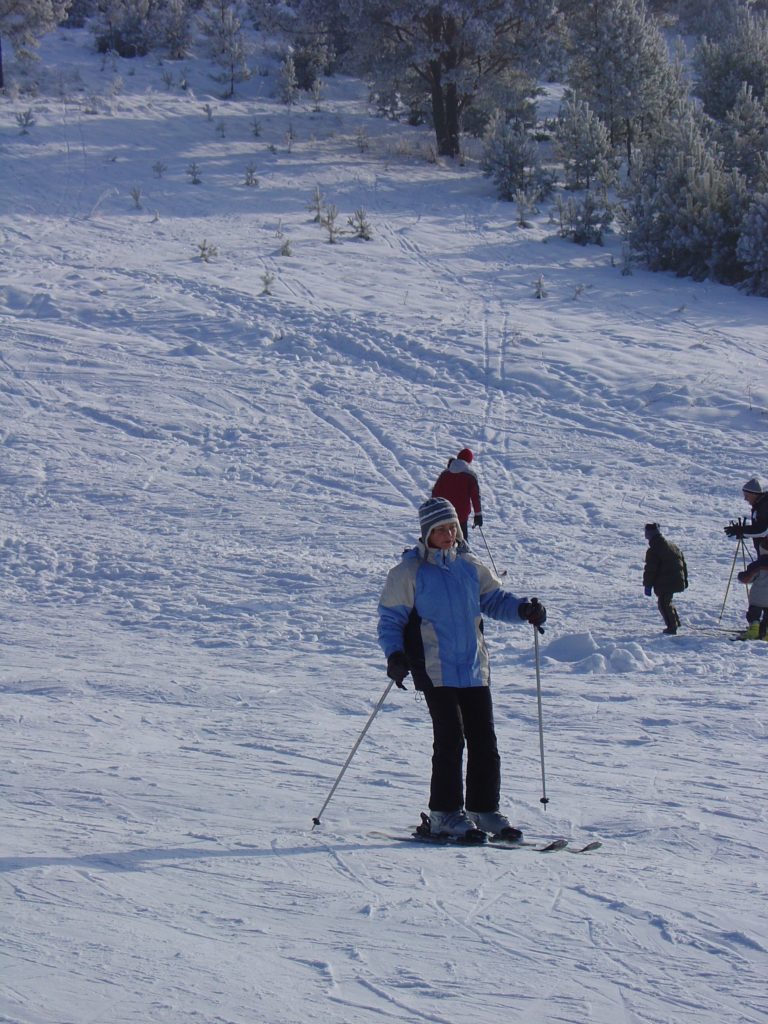 Dwie Doliny - wyciąg krzesełkowy Szczawnik I in Poland - a group of people skiing down a snowy hill.