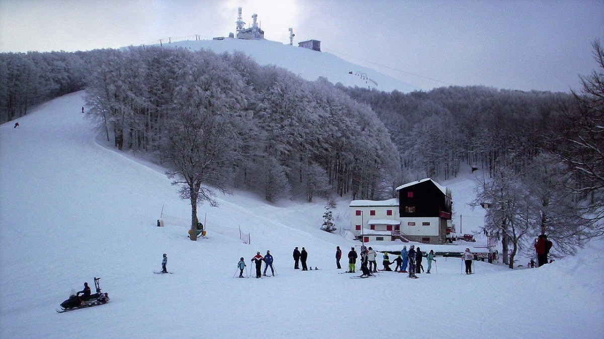 Monte Terminillo in Italy - a group of people skiing down a snow covered mountain.