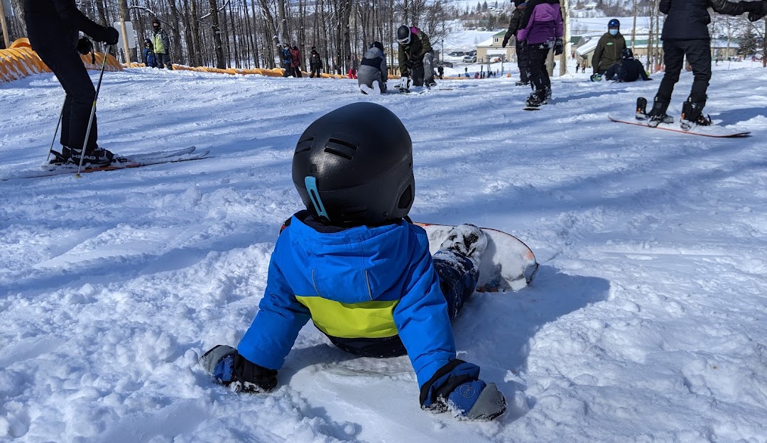 A snowboarder dynamically carving down a snowy slope at Mont Rigaud Quebec Canada showcasing the thrilling sense of speed and freedom snowboarding offers.