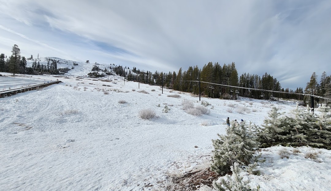 Winter sports scene at Soda Springs in Lake Tahoe, California showcasing a bustling ski resort, a ski lift in operation, and stunning winter scenery.