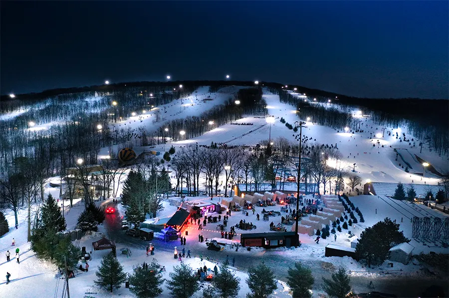 Montage Mountain Resort in USA - a ski slope at night with people skiing.