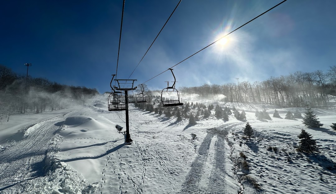 View of Montage Mountain Resort in Scranton, Pennsylvania showing a ski lift ascending snow-covered slopes. The setting is a vibrant winter sports scene at a ski resort.