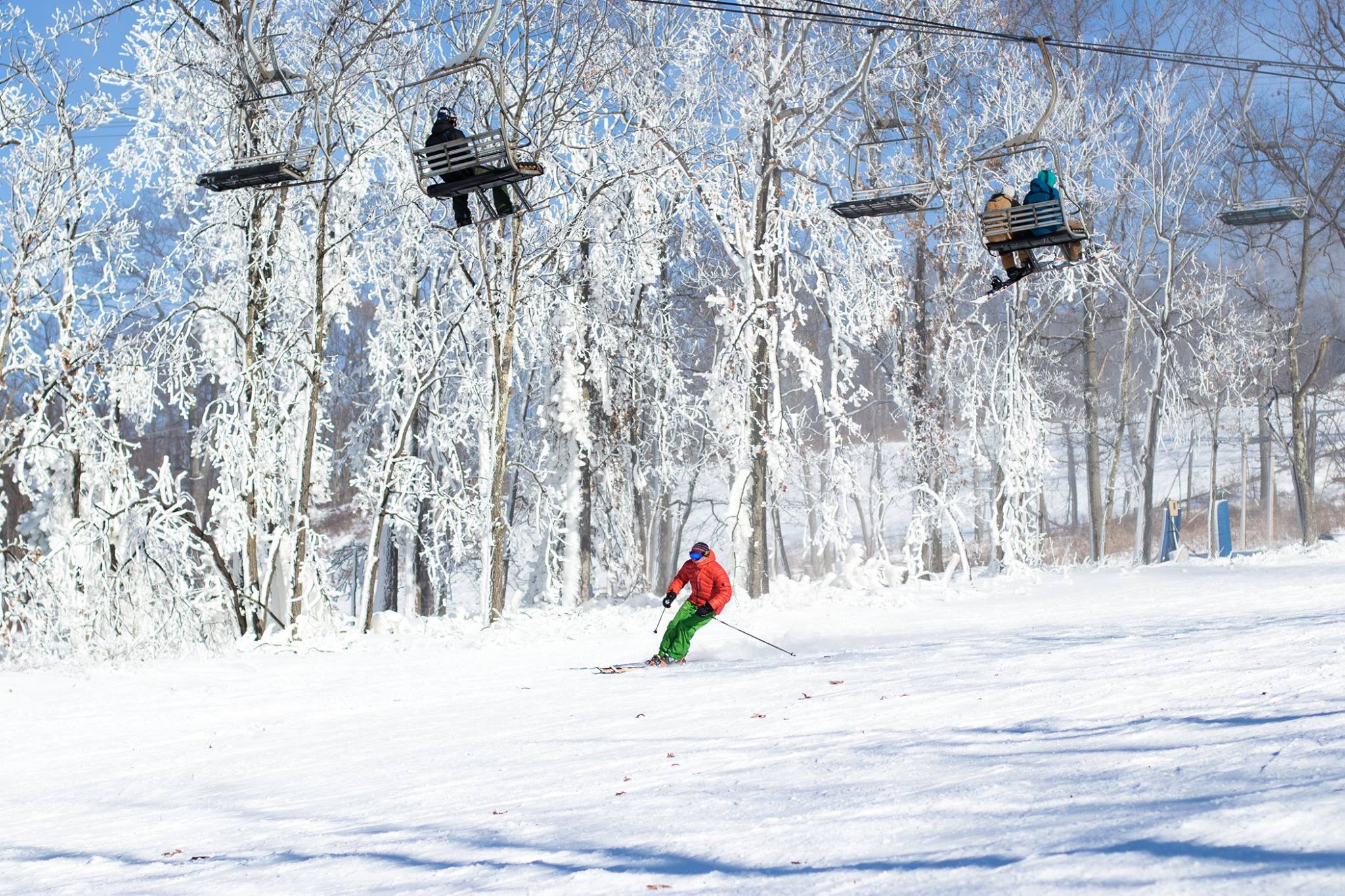 A winter sports scene at Montage Mountain Resort in Scranton Pennsylvania featuring a ski lift skiers and snowboarders enjoying the snow-covered slopes.