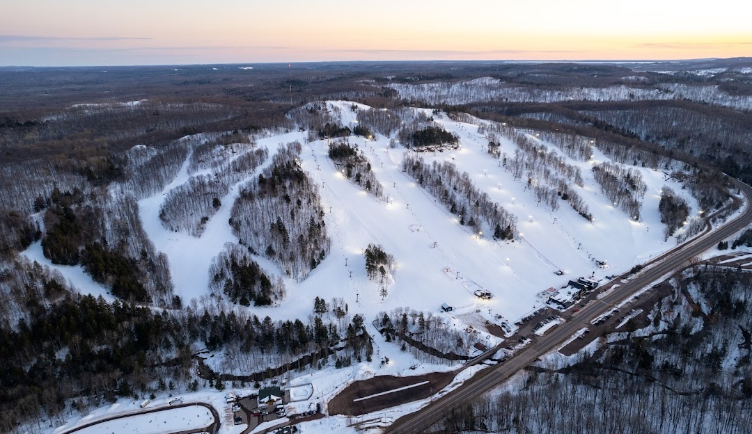 A lively ski resort at Marquette Mountain, Michigan, bustling with winter sports activities. Snow-covered slopes and ski lifts shape the stunning winter scenery.