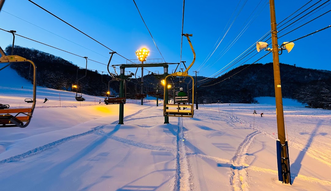 Image of the Moiwayama Ski Jominamishamen in Japan, featuring a ski lift ascending the snow-covered slopes, skiers in action amidst picturesque winter scenery at a ski resort.