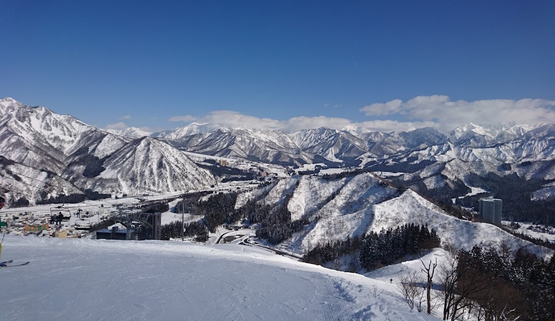 A captivating winter scene at Naspa Ski Garden Chūbu Japan showcasing a bustling ski resort. Majestic mountains cradle the vibrant winter sports scene covered in a blanket of pristine snow.