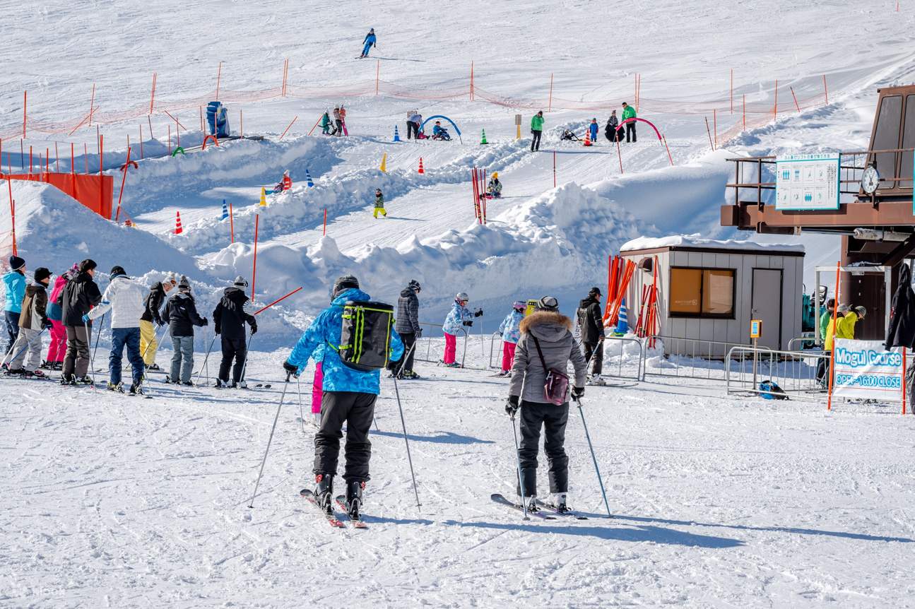 Naspa Ski Garden in Japan - a group of people skiing down a snowy slope.