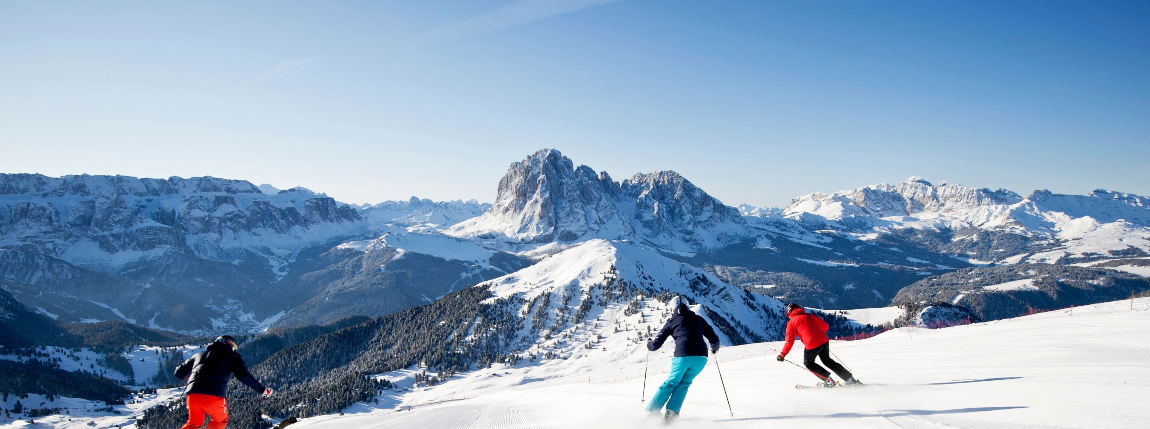 Val Gardena in Italy - a group of people skiing down a snowy mountain.