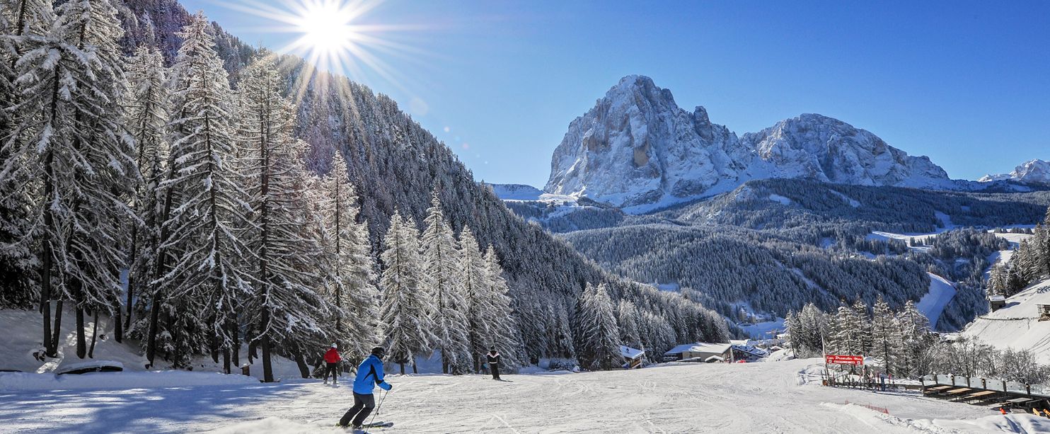Val Gardena in Italy - a group of people skiing down a snow covered mountain.