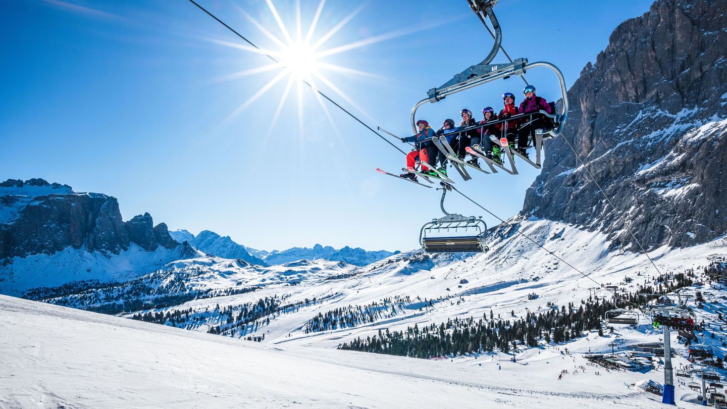 Val Gardena in Italy - two people riding on a ski lift in the mountains.
