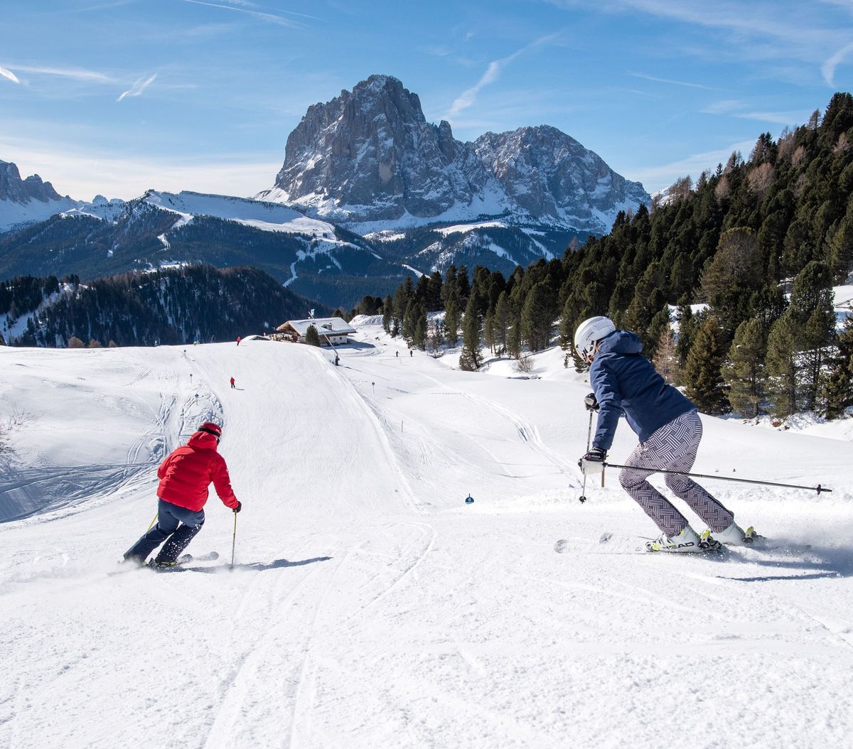 Val Gardena in Italy - a couple of people skiing down a snowy slope.