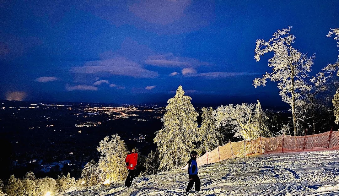 Winter sports enthusiasts enjoying the charming slopes of a ski resort on West Mountain, Queensbury, New York. The stunning winter landscape of The Adirondacks enhances the captivating scene.