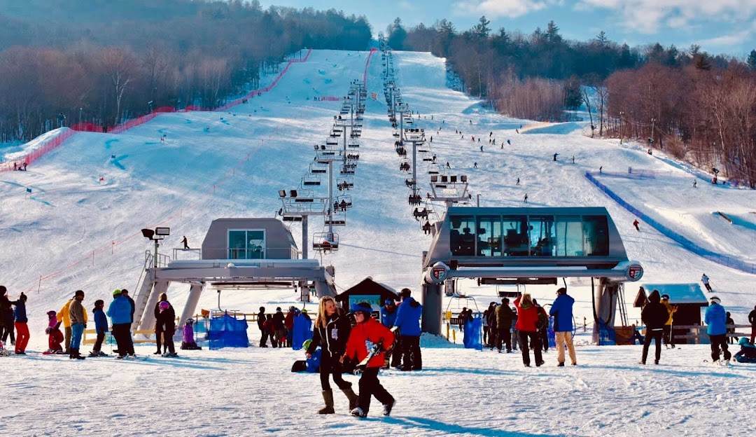 View of West Mountain ski resort in The Adirondacks, Queensbury, NY, highlighting ski lifts amid a picturesque winter landscape bustling with winter sports activities.