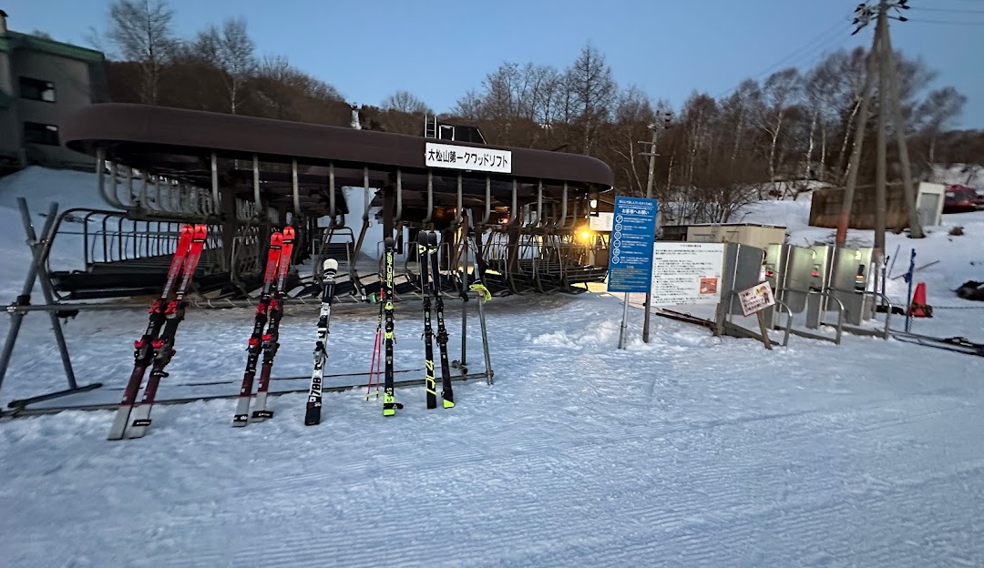 Winter sports scene at Pine Beak in Chūbu, Japan with visible ski resort, a functioning ski lift, and a family enjoying skiing.