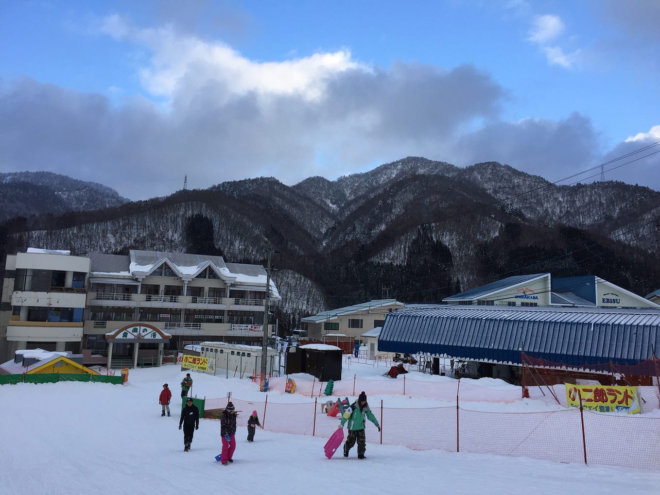 Honokidaira in Japan - a group of people skiing down a snow covered slope.