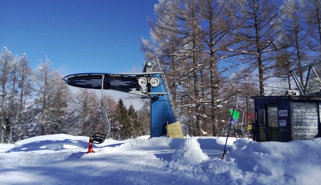 A lively winter sports scene at Rewild Ninja Snow Highland in Japan, showcasing a ski resort with an operational ski lift, enthusiastic skiers, and a snowmobile.