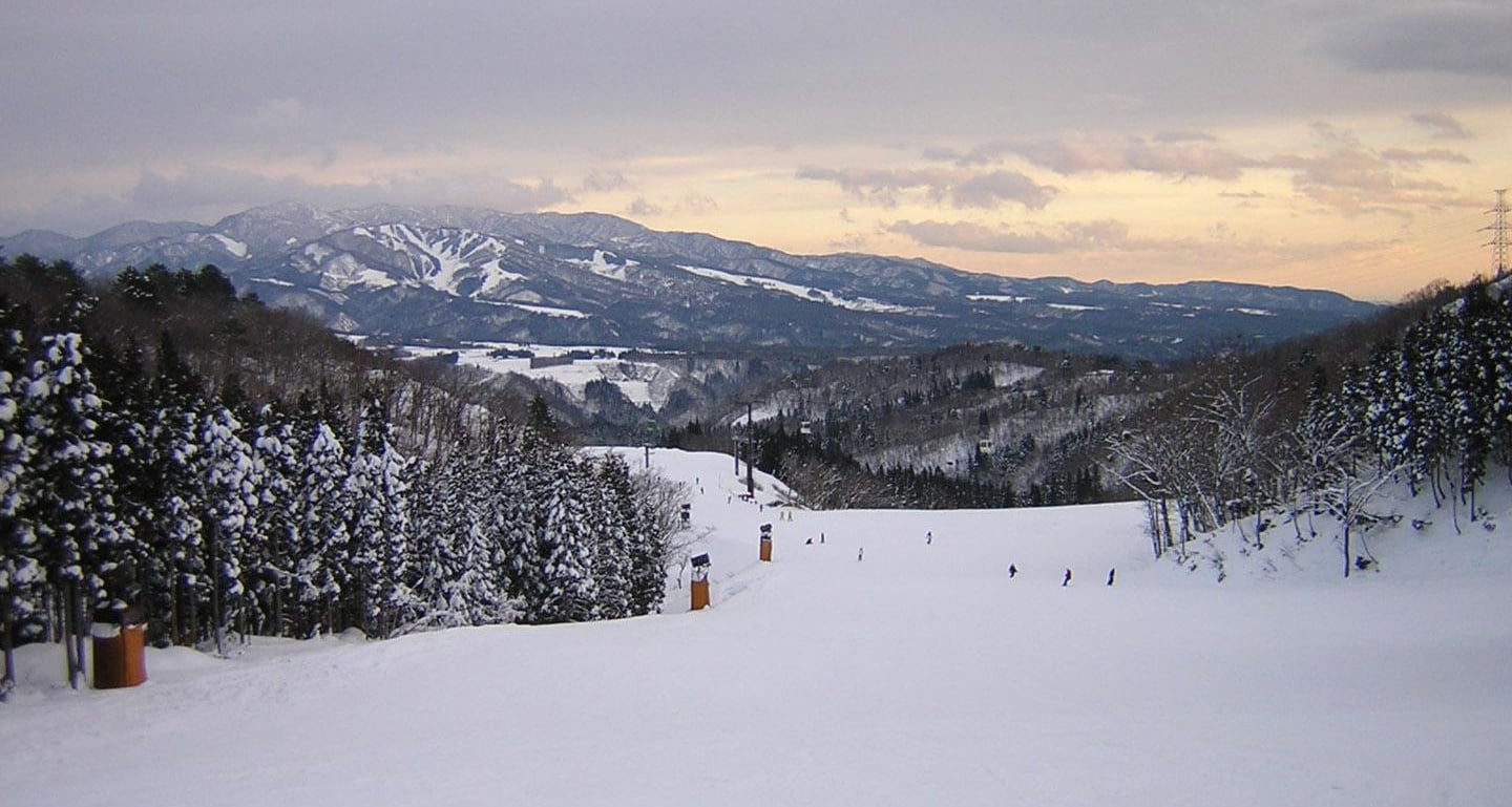 Star Spur Ryokufu Resort Hida Nagareha in Japan - a snow covered ski slope with mountains in the background.