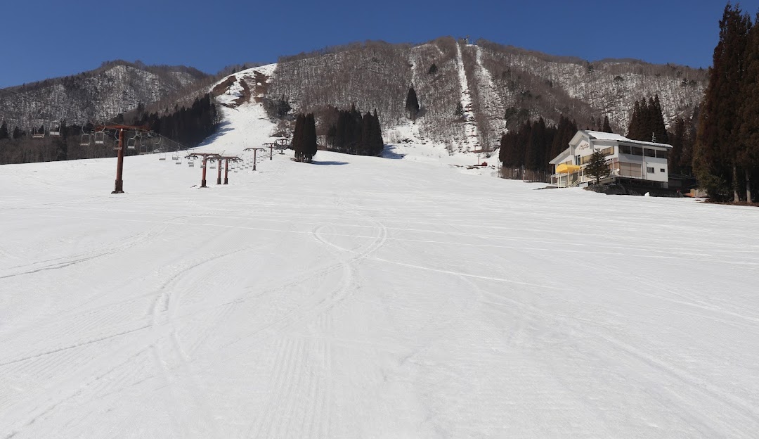 View of the scenic Star Spur Ryokufu Resort in Hida Nagareha, Japan, featuring a bustling ski resort with a ski lift. Winter sports activities visible against the backdrop of a quaint challet.