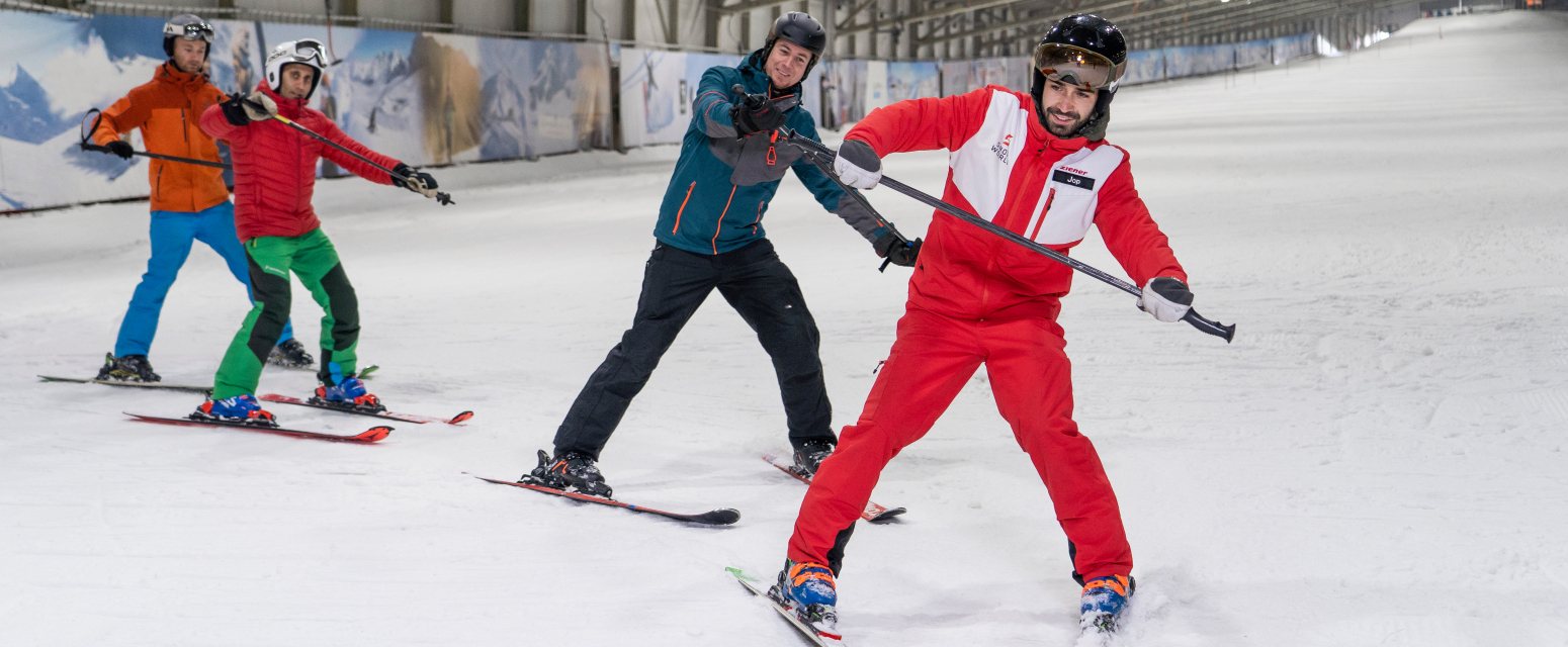 SnowWorld Rucphen in Netherlands - a group of people skiing down a snow covered slope.
