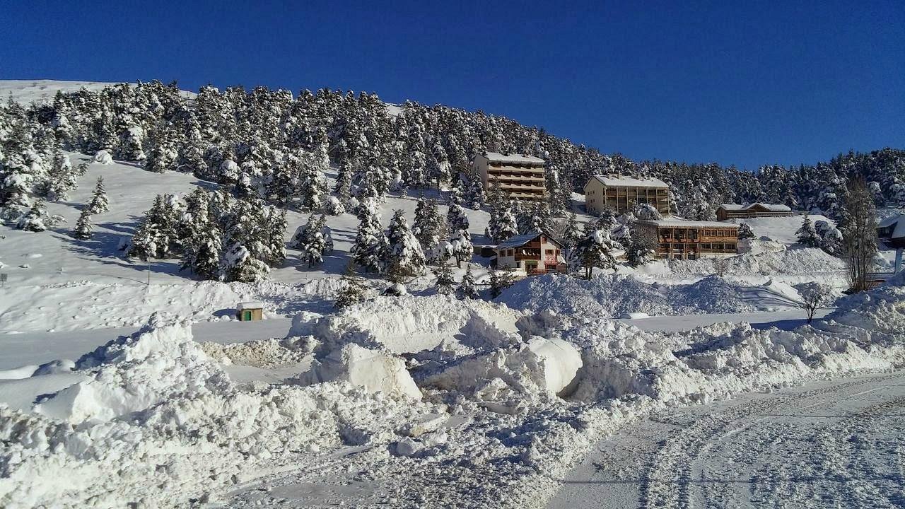 Ski resort at Gréolières Les Neiges in France showing a challet in a picturesque winter setting with snow sports activities underway.