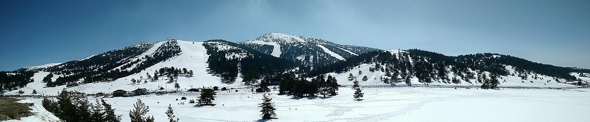 View of a snowy peak at Gréolières Les Neiges, France, featuring a chalet nestled amidst the white landscape. A scene encapsulating winter sports and enchanting winter scenery.