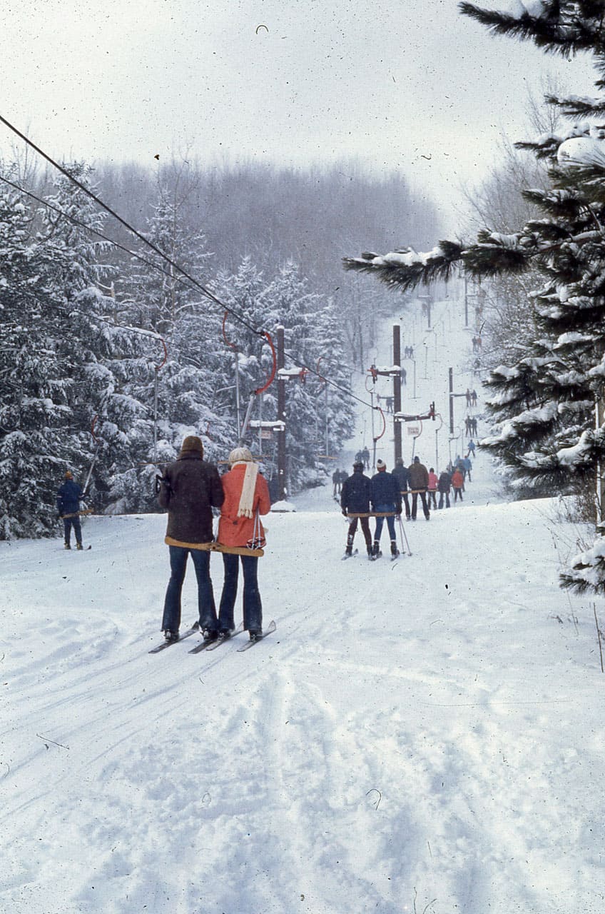 Peek n Peak in USA - a group of people skiing down a snowy hill.
