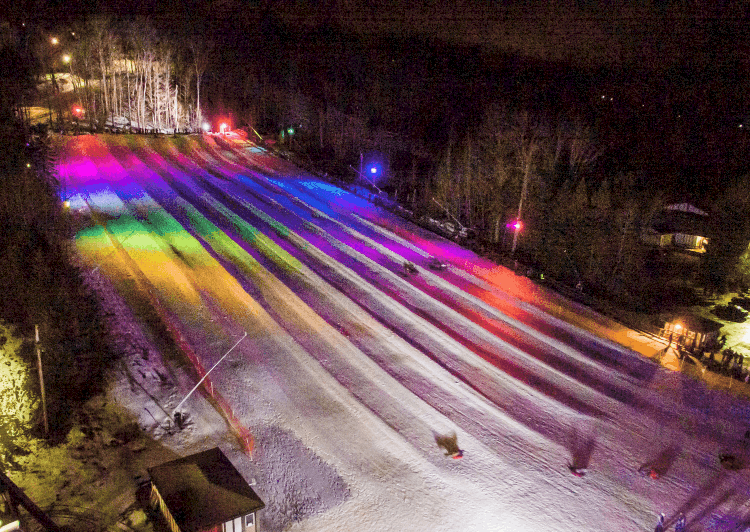 Winter scene at the Peek n Peak resort in Clymer, New York, showcasing a ski resort with busy ski lifts and skiers on snowy slopes.