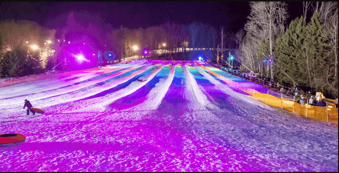 Winter scene at Peek n Peak, New York, featuring snow-covered slopes busy with winter sports, a snowmobile and a chalet nestled in the stunning snowy landscape. Leisurely activities at a winter sports centre.